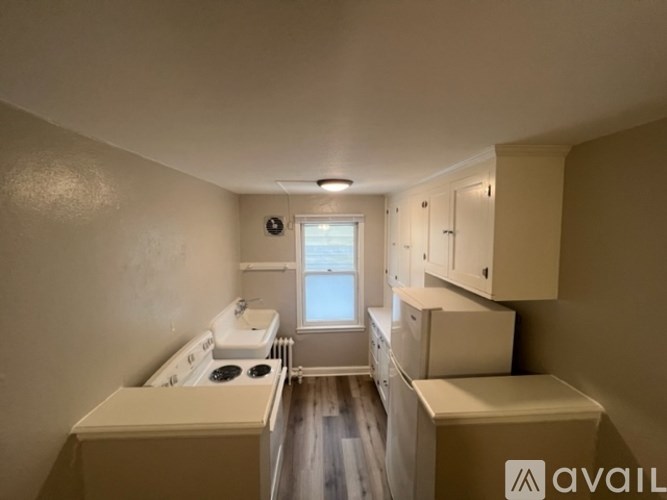 A kitchen with a stove, sink, and cabinets is available for rent.