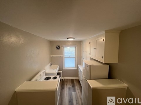 A kitchen with a stove, sink, and cabinets is available for rent.