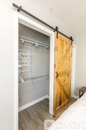 A bedroom with a bed and a sliding door leading to a walk-in closet.