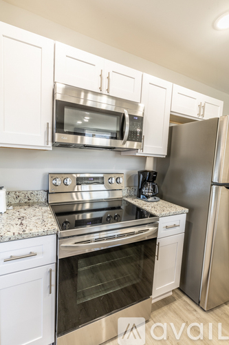 A kitchen with white cabinets and stainless steel appliances.