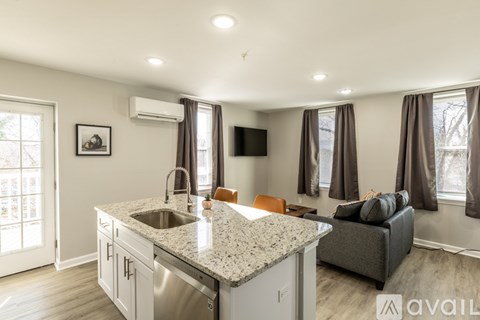 A kitchen with a granite countertop and a stainless steel sink.