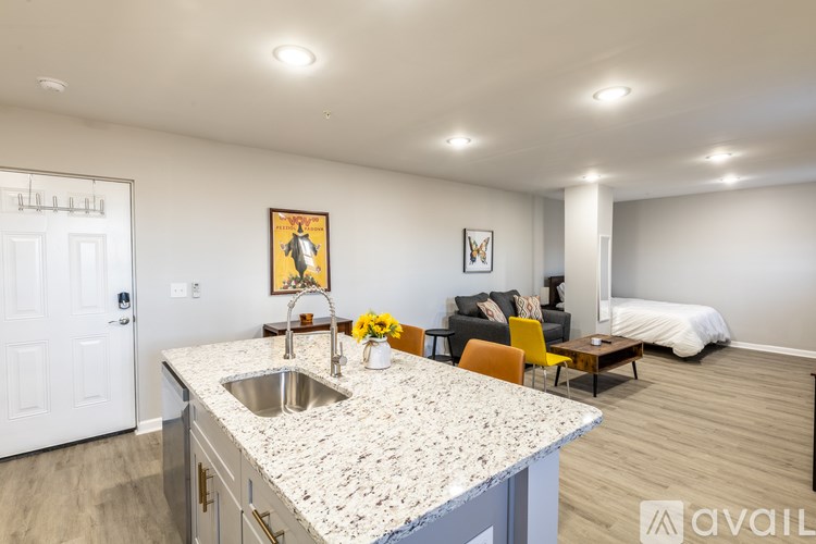 A kitchen with a sink and a painting of a man on the wall.
