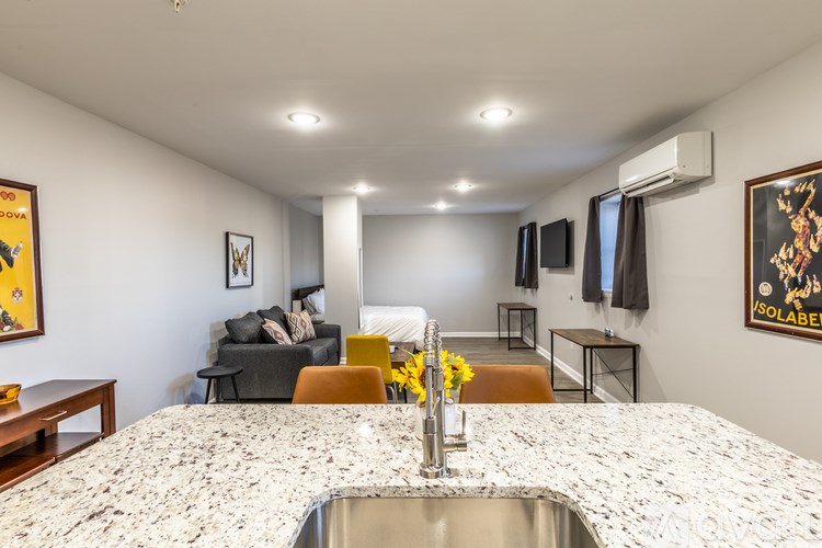 A kitchen with a marble countertop and a sink.