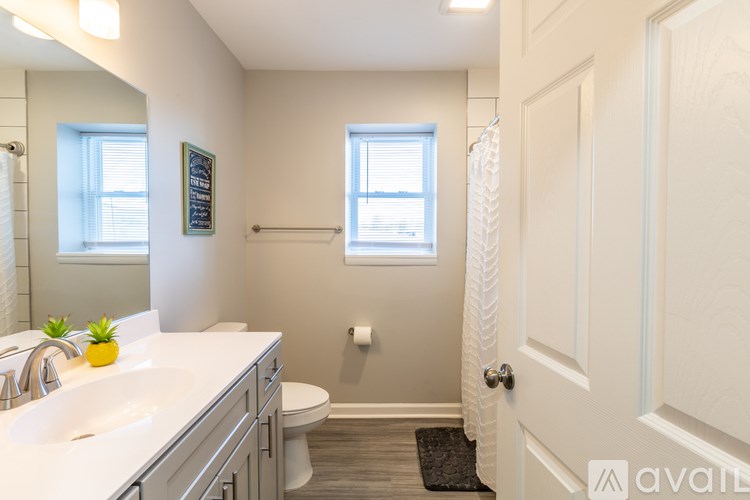 A bathroom with a sink, toilet, and a window.