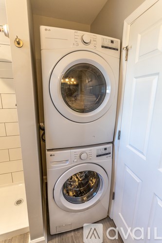 A white front loading washing machine in a small laundry room.