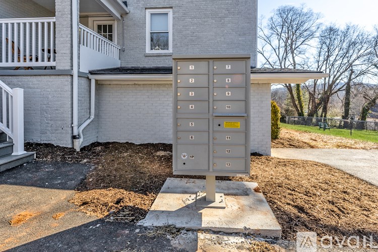 A grey building with a sign in front of it.