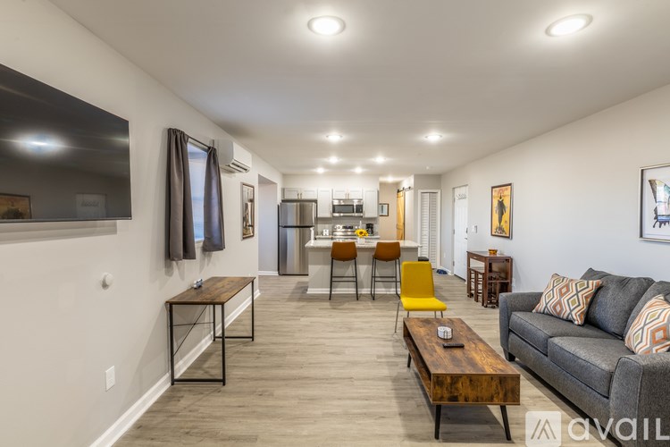 A living room with a grey couch, a wooden coffee table, and a yellow chair.