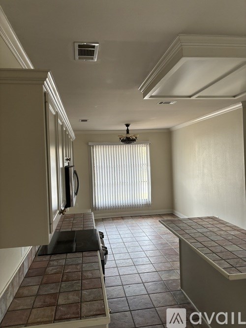 A room with a tiled floor and a window with blinds.