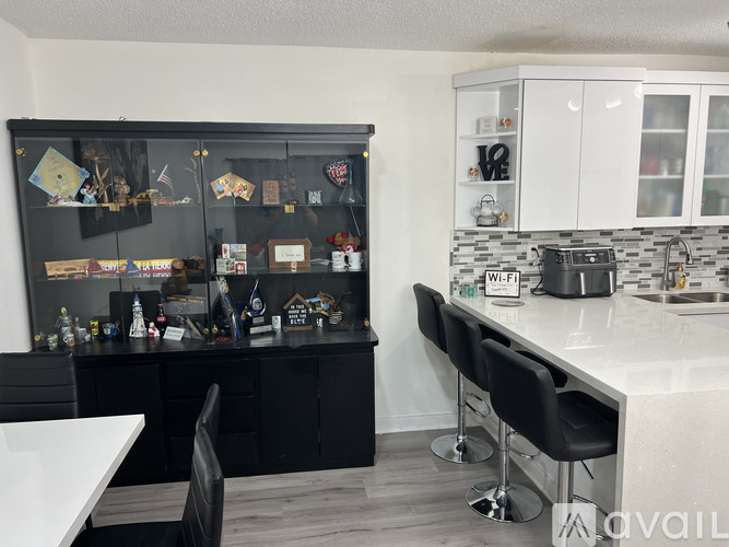 A kitchen with black cabinets and a white countertop.