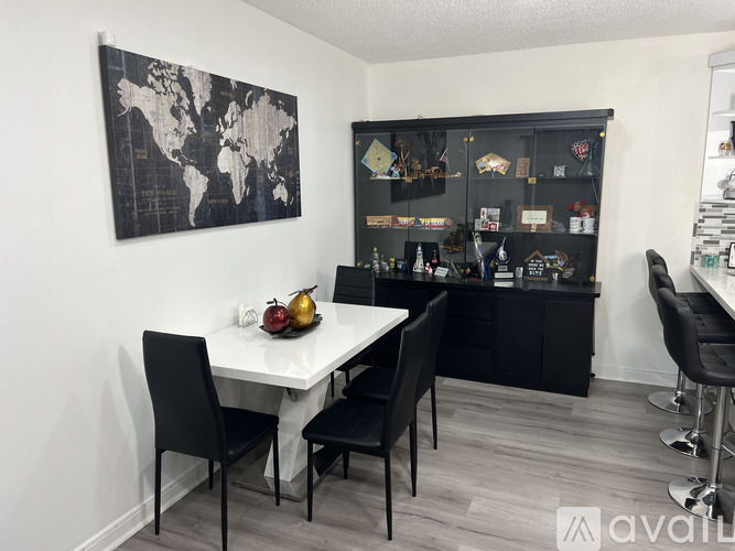 A dining room with a white table and black chairs.