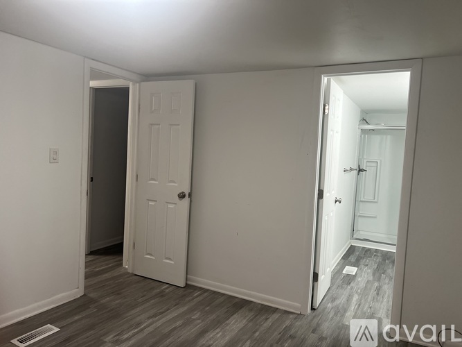 A room with a white door and a white wall.