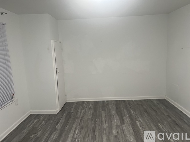 A room with wooden flooring and a white door.