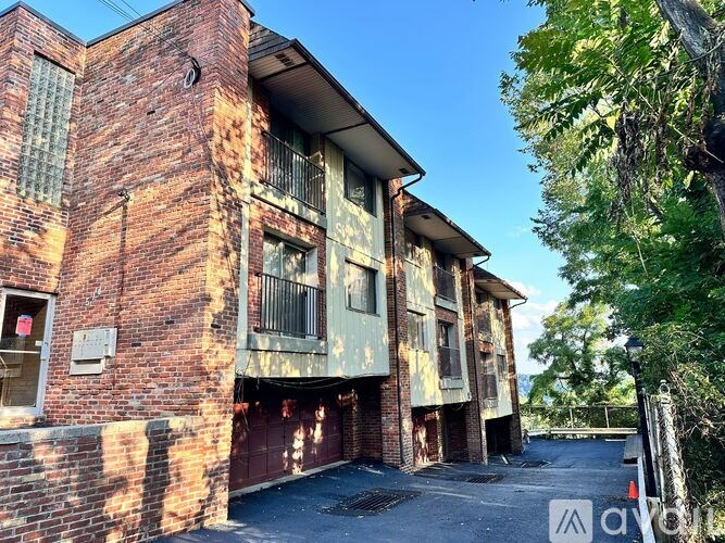 A red brick building with a green tree on the right side.