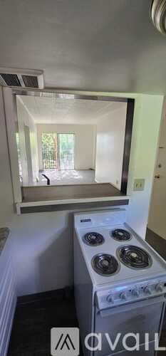 A stove with a window above it is in a room.