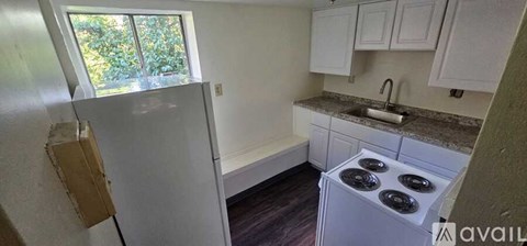 A kitchen with a white stove and cabinets.