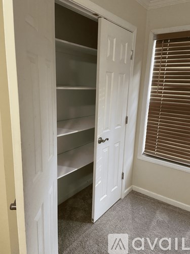 A white closet door with shelves and a handle.
