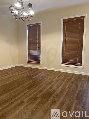 A room with wooden flooring and a chandelier.