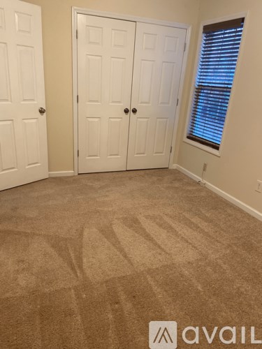 A room with two doors and a carpeted floor.