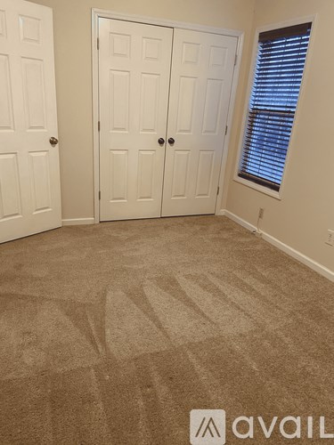 A room with two doors and a carpeted floor.
