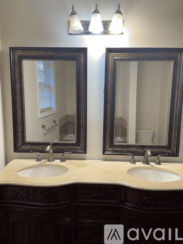 A bathroom with two sinks and two mirrors.
