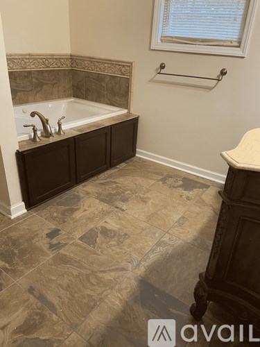A bathroom with a tub and a window.