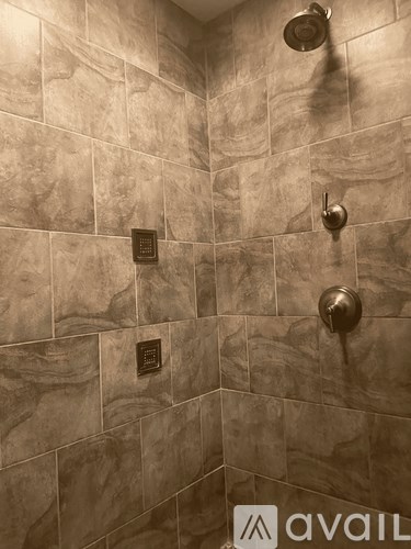 A shower area with Avail sign on the wall.