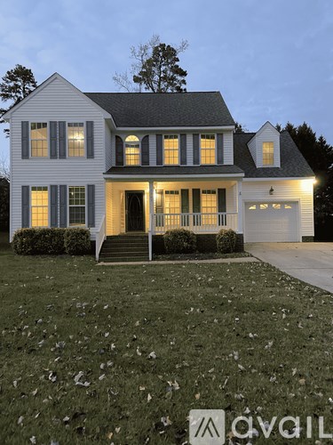A white house with a black roof and a garage.