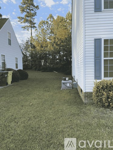 A white house with a blue window and a white fence.