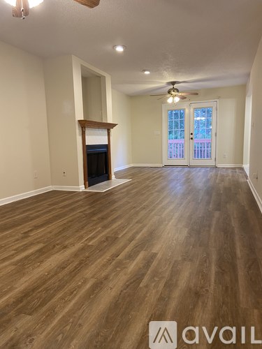 A room with wooden flooring and a ceiling fan.