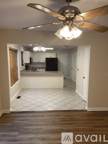 A kitchen with a fan and a fridge.