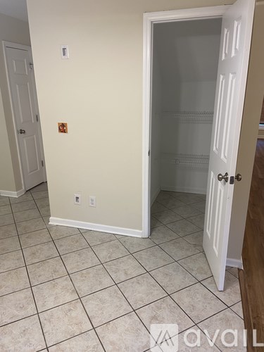 A room with a white door and tiled floor.