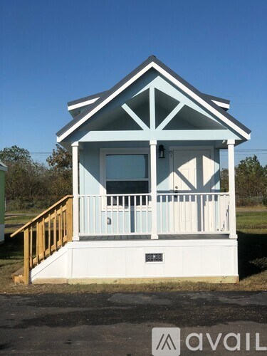 A small house with a porch and a white door.