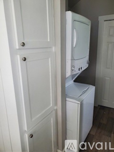 A white fridge and freezer are in a room with a white door.