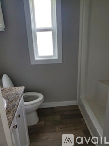 A bathroom with a toilet and a window.