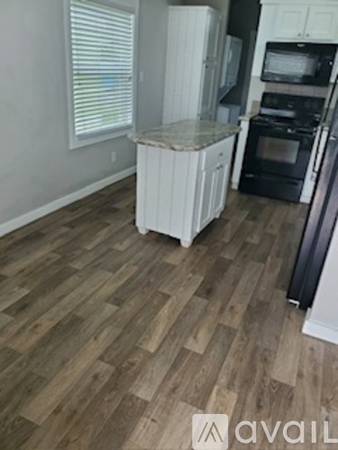 A kitchen with a white refrigerator and black appliances.