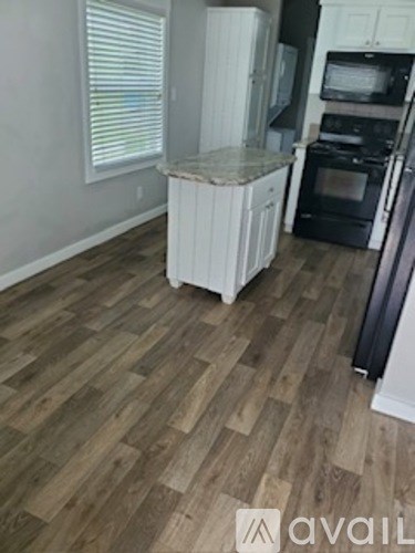 A kitchen with a white refrigerator and black appliances.