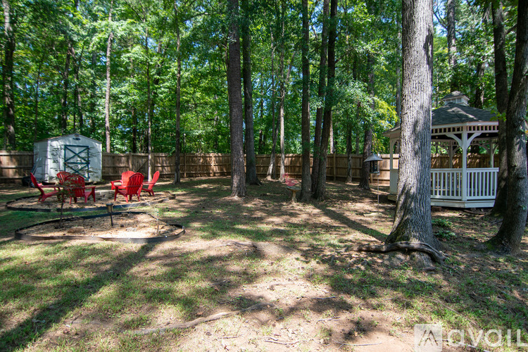 A backyard with a swing set and a gazebo.
