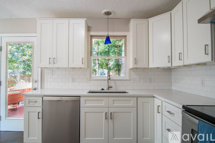 A kitchen with white cabinets and a stainless steel dishwasher.