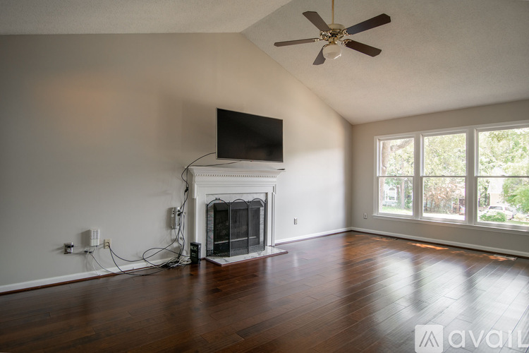 A living room with a fireplace and a flat screen TV mounted above it.