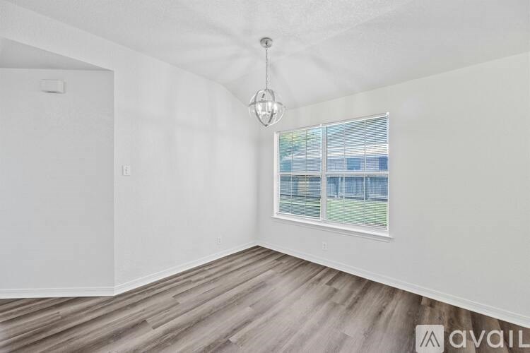 A room with a window overlooking a fenced area.