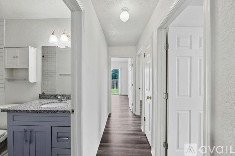 A long hallway with white doors and a marble counter top.