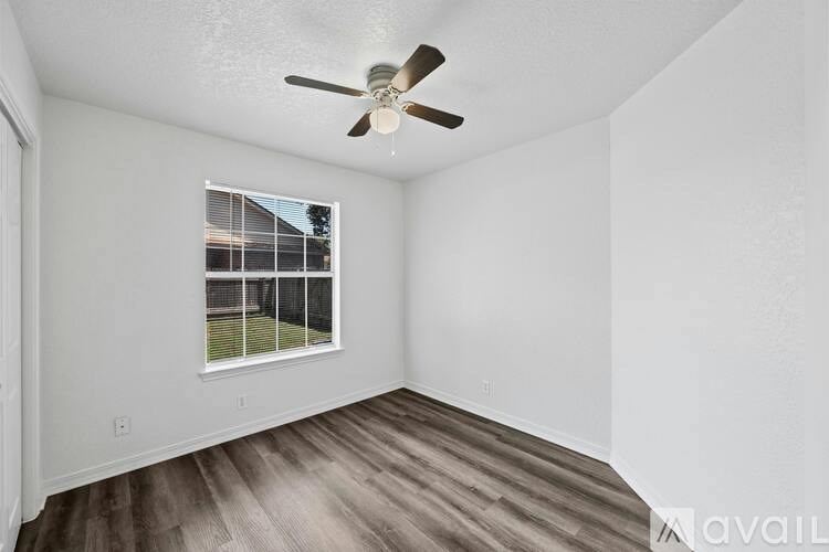 A room with a ceiling fan and a window with blinds.
