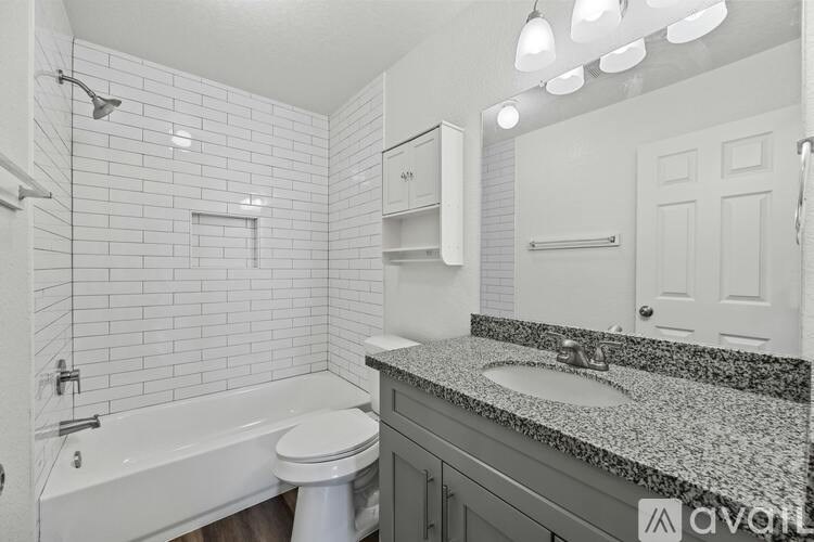 A bathroom with a white tub, toilet, and sink.