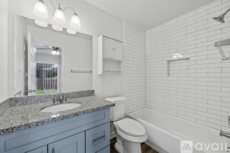 A bathroom with a white tub, sink, and toilet.