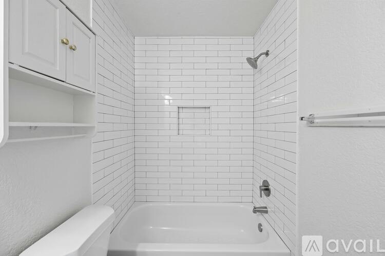 A white bathroom with a tub and a toilet.