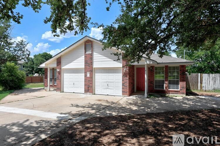 A house with a red door and two garage doors is for sale.
