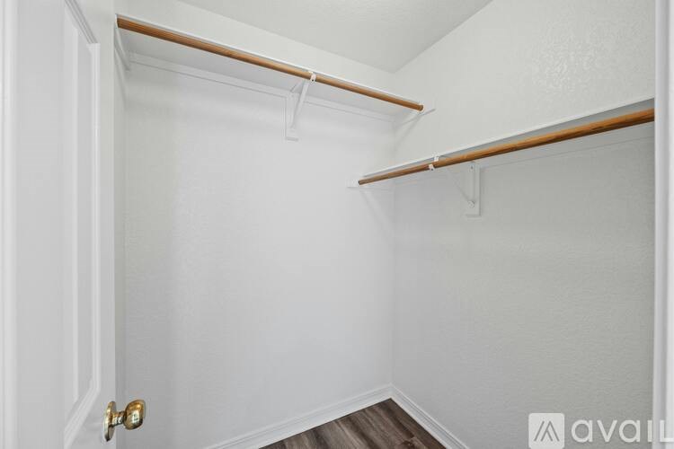 A white closet with a door and a shelf.