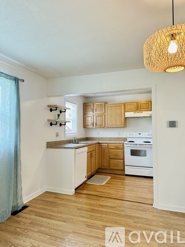 A kitchen with wooden cabinets and a white stove top oven.