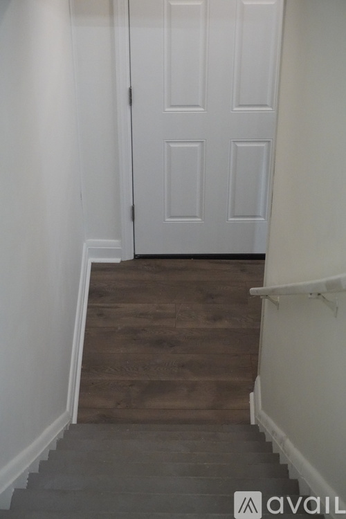 A white door is at the end of a flight of stairs.