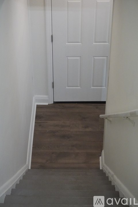 A white door is at the end of a flight of stairs.